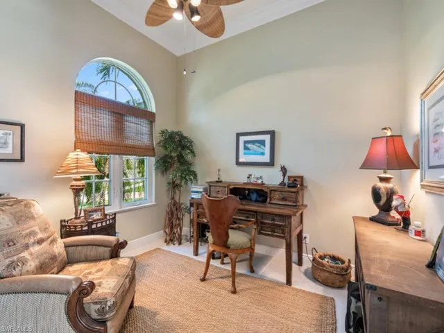 Tiled home office with plenty of natural light, ceiling fan, crown molding, high vaulted ceiling, and baseboards