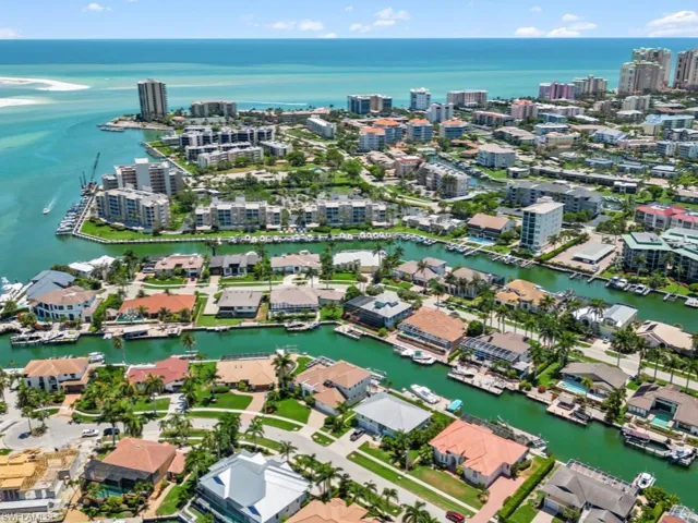 Aerial view of property and surrounding area with a nearby body of water and nearby urban area