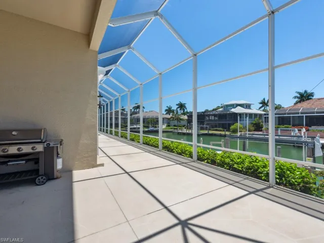 View of patio with a water view, a lanai, and a residential view