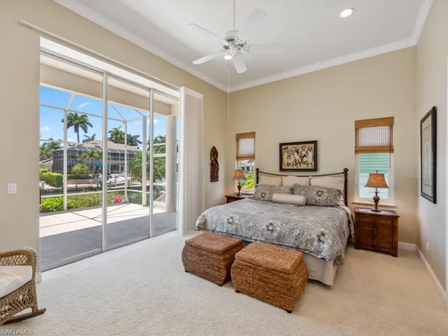Bedroom featuring carpet, access to exterior, ornamental molding, baseboards, and a ceiling fan