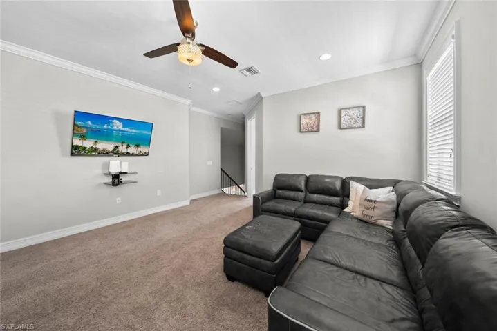 Multi purpose room featuring carpet, ceiling fan, and ornamental molding