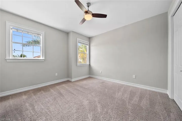Carpeted spare room featuring ceiling fan