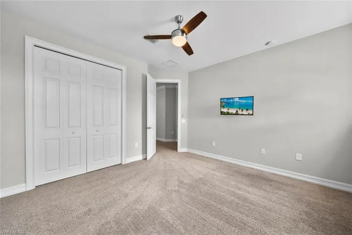 2nd floor bedroom with light colored carpet, ceiling fan, and a closet