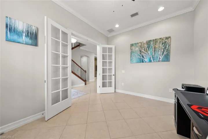 Tiled office featuring crown molding and french doors