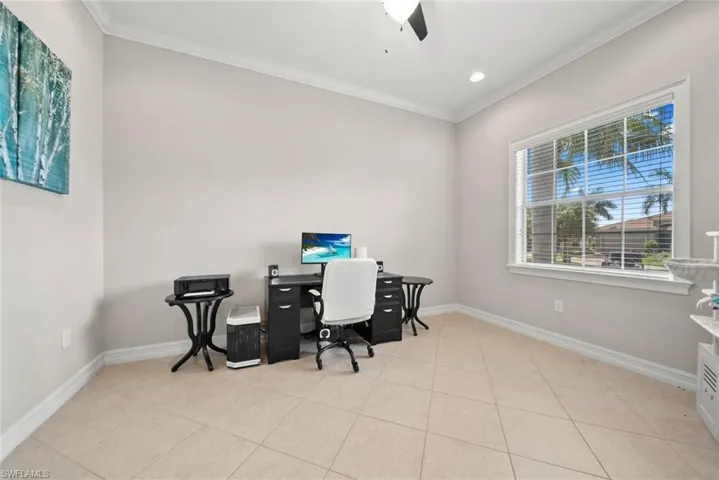 Tiled home office featuring ornamental molding and ceiling fan
