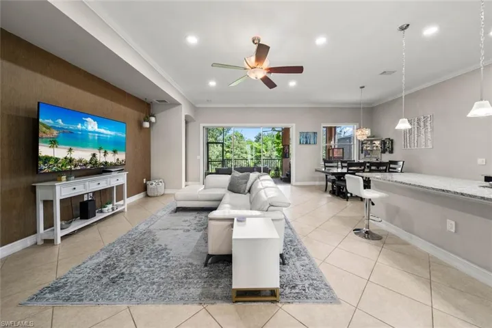 Tiled living room with crown molding and ceiling fan
