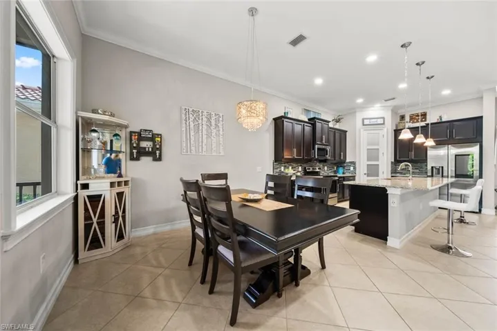 Tiled dining space with crown molding,