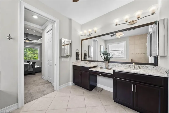 Primary Bathroom with tile patterned floors, ceiling fan, ornamental molding, and vanity