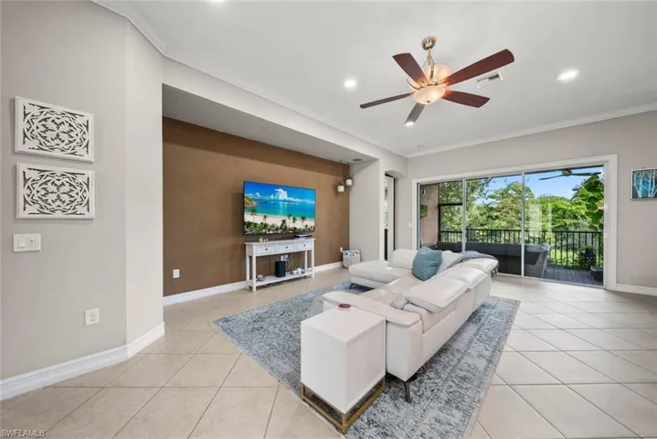 Tiled living room featuring crown molding and ceiling fan