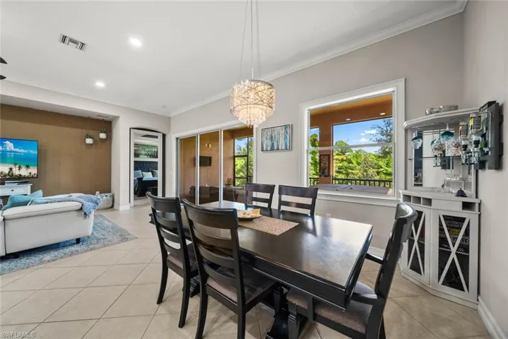 Tiled dining room featuring ornamental molding and a chandelier