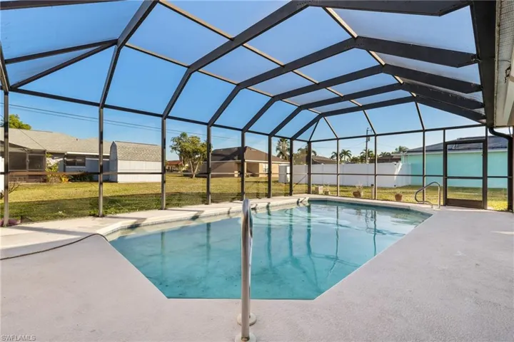 View of swimming pool with a lawn and a lanai