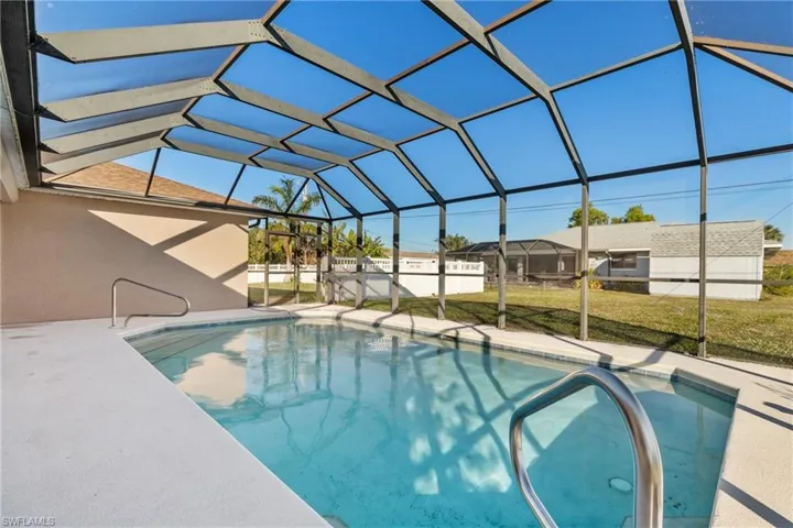 View of pool with a lawn, a patio area, and a lanai