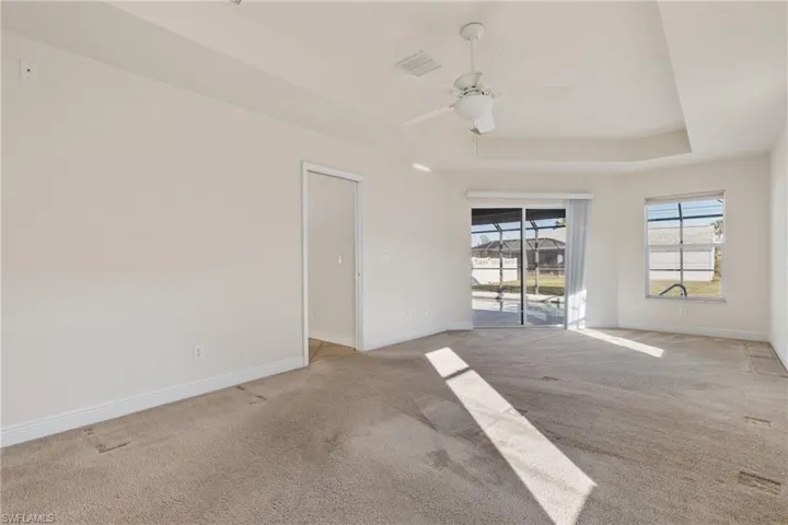 Master bedroom room with a tray ceiling and ceiling fan