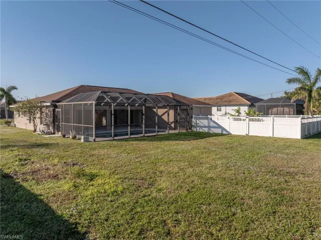 Rear view of property with a yard