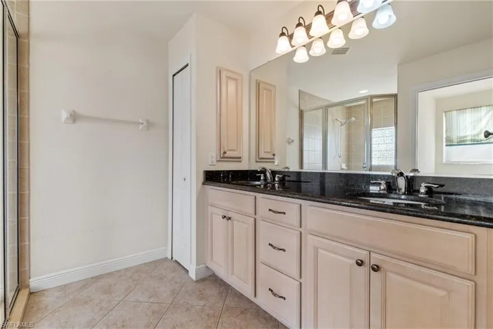 Bathroom with tile patterned floors, vanity, and walk in shower