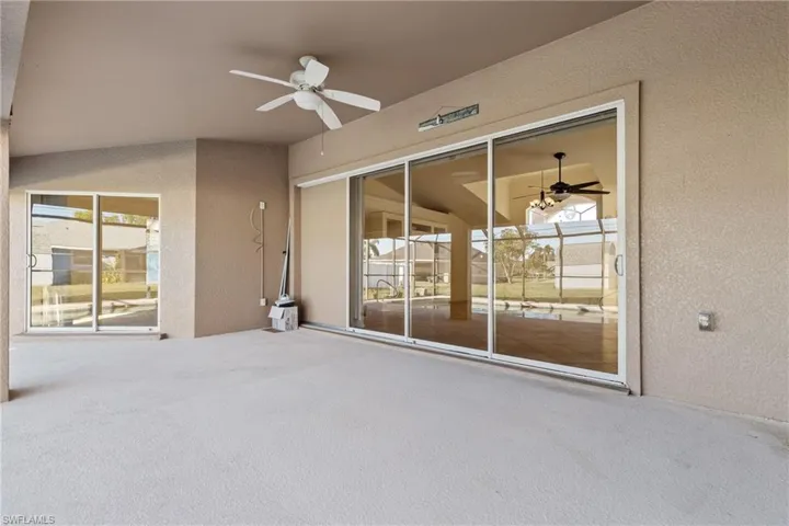 View lanai with sliders to living and master featuring ceiling fan