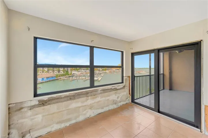 Unfurnished room with a water view and tile patterned flooring
