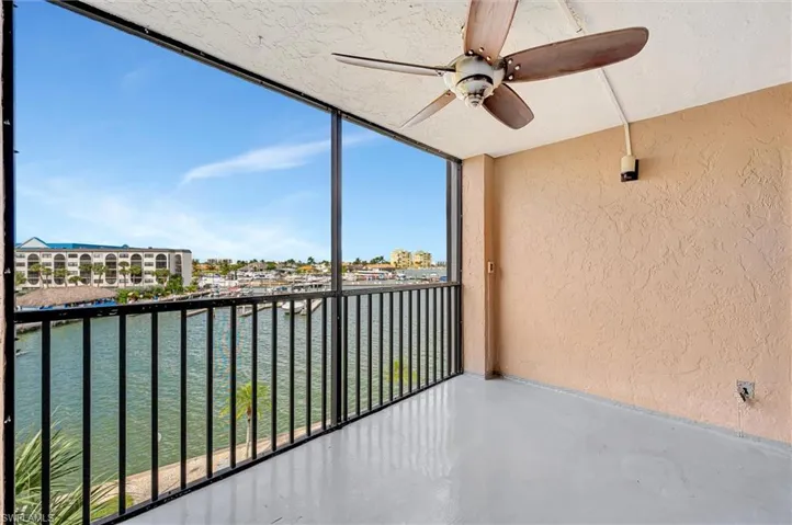 Balcony with ceiling fan, a sunroom, and a water view