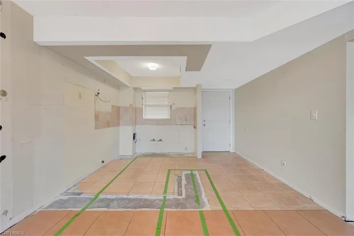 Unfurnished room with light tile patterned flooring and baseboards