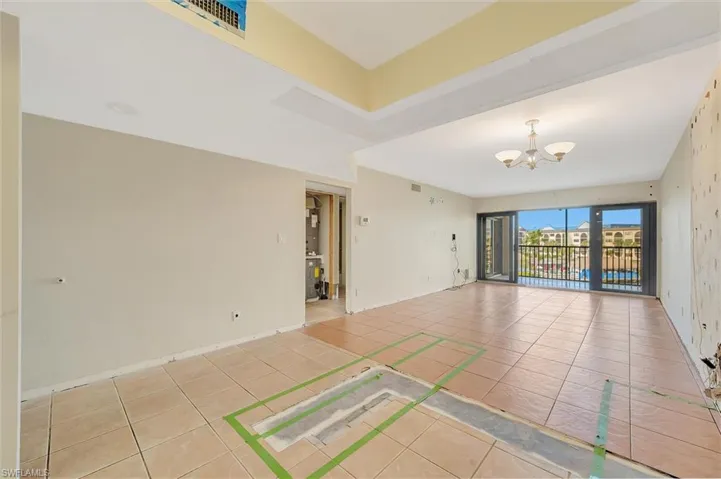 Spare room featuring light tile patterned floors and a chandelier
