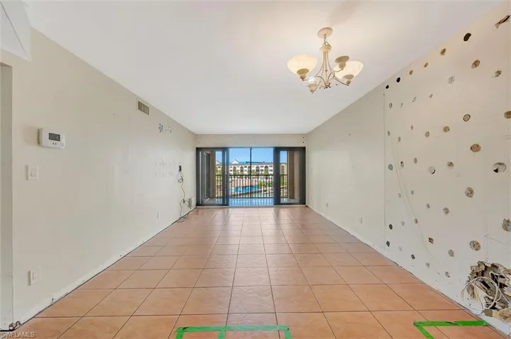Tiled empty room with a chandelier