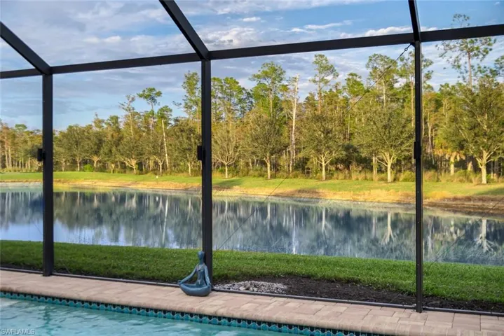 Swimming pool featuring screen enclosure, a sunroom, a water view, and a yard