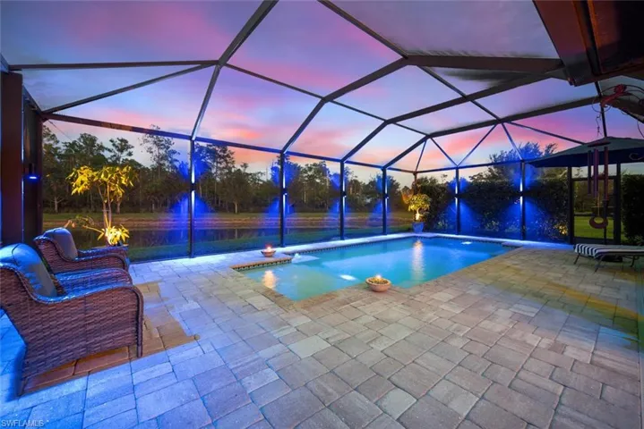 Swimming pool featuring a lanai, a sunroom, and a patio area
