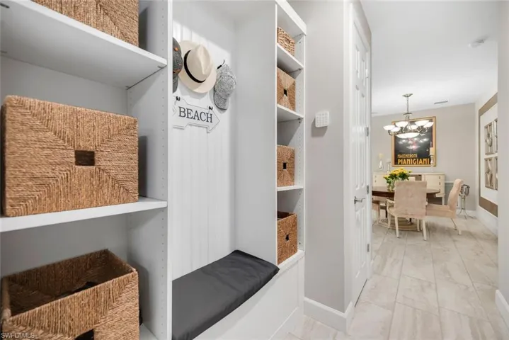 Mudroom featuring a chandelier and marble finish floors