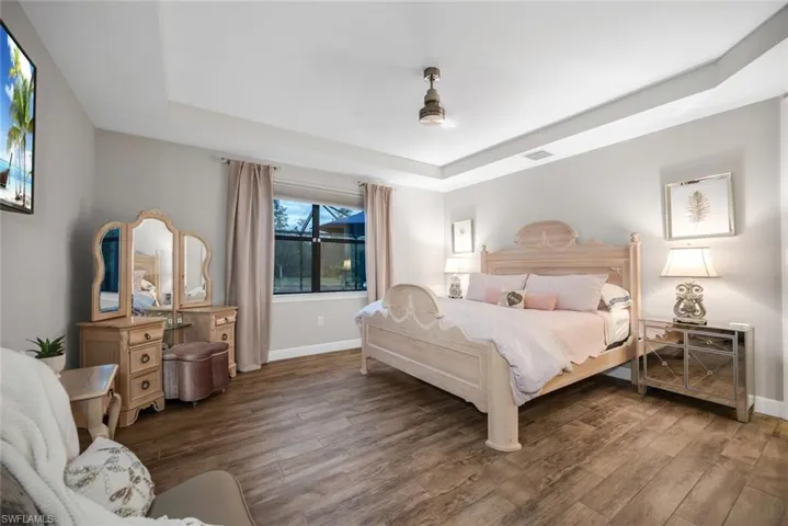 Bedroom featuring a raised ceiling and wood finished floors