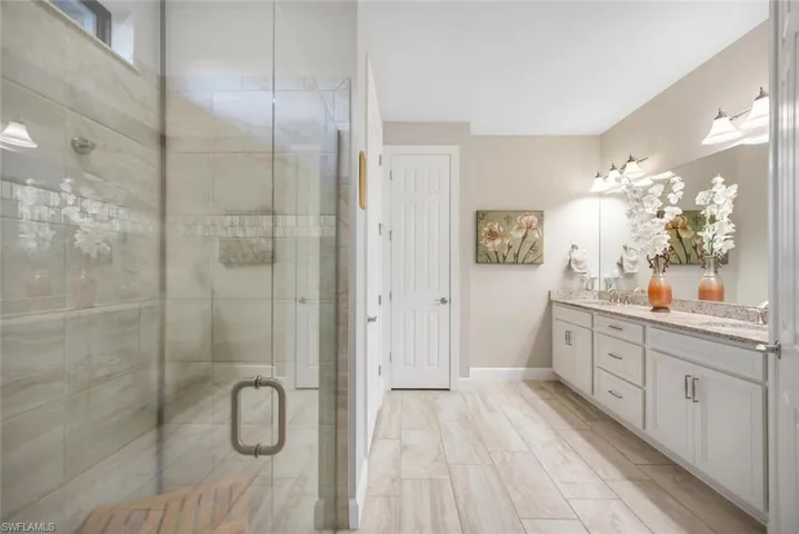 Bathroom featuring double vanity and a stall shower