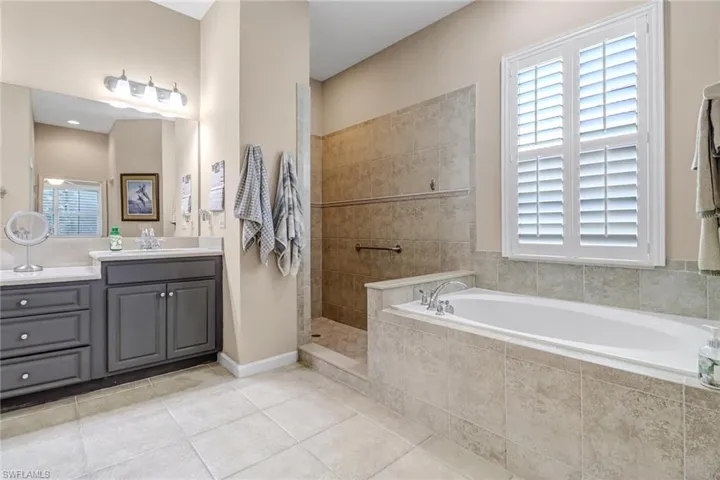 Bathroom with separate shower and tub, tile floors, and large vanity