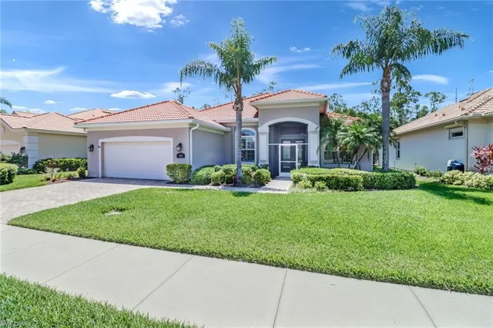 Mediterranean / spanish-style house with a garage and a front lawn