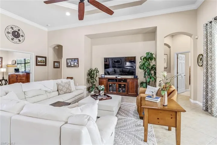 Tiled living room featuring ornamental molding and ceiling fan