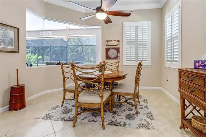 Tiled dining area featuring a healthy amount of sunlight, ceiling fan, and crown molding