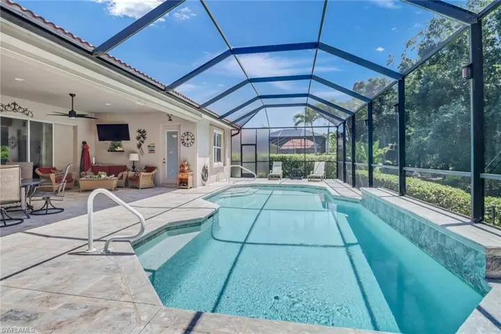 View of swimming pool with outdoor lounge area, a lanai, a patio area, and ceiling fan