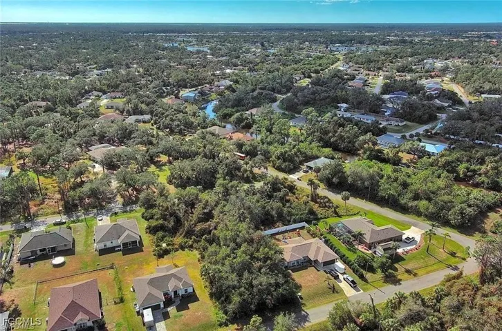 Aerial view of property and surrounding area featuring nearby suburban area