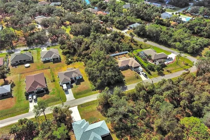 Aerial view of property and surrounding area with nearby suburban area