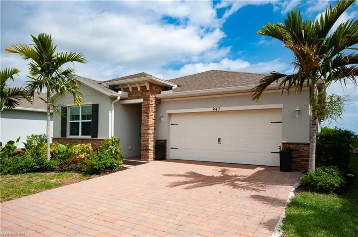Contemporary single-story residence with a tan stucco exterior and dark brown roof