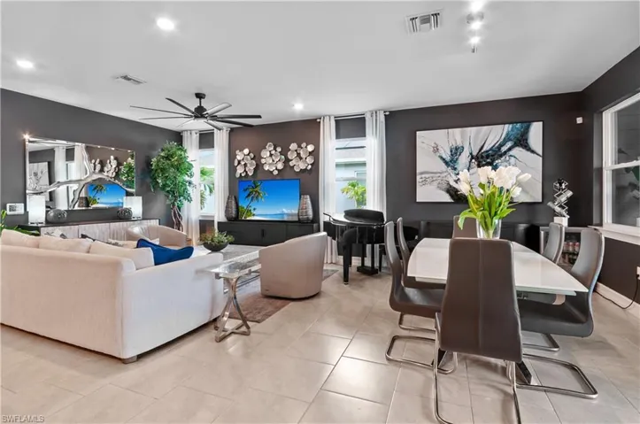 Open-concept living area featuring a black ceiling fan with integrated lighting, recessed lighting, and tile flooring