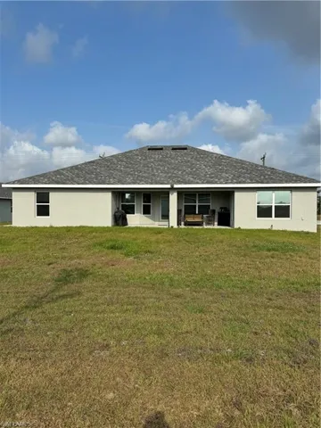 Back of house featuring a yard