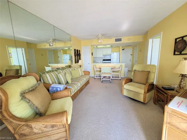 Carpeted living area featuring a textured ceiling and a ceiling fan