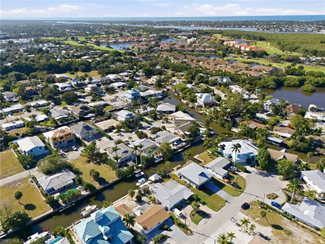 Aerial view of property and surrounding area with a nearby body of water and nearby suburban area
