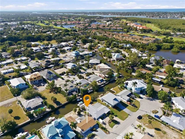 Aerial view of property and surrounding area with a nearby body of water and nearby suburban area