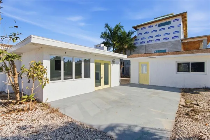 Rear view of house with a patio area, french doors, and stucco siding