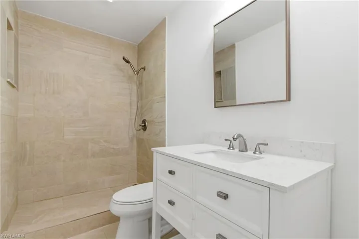 Bathroom featuring vanity and a tile shower