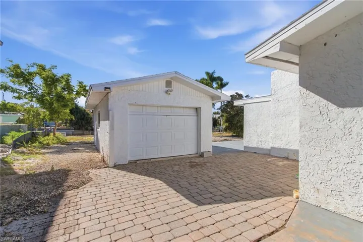 Detached garage featuring decorative driveway