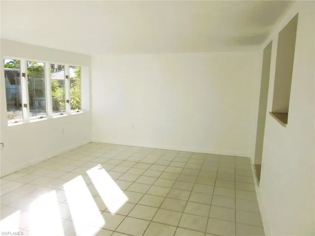 Empty room featuring baseboards and light tile patterned flooring