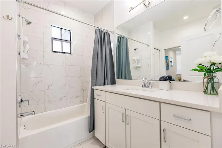 Bathroom with tile flooring, vanity, and shower / bath combo with shower curtain