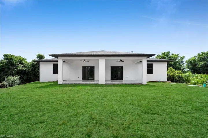 Expansive rear yard featuring a manicured lawn