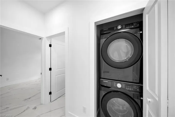 Integrated laundry closet with stacked black appliances